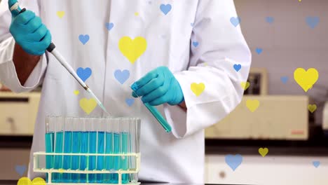 Animation-of-yellow-and-blue-hearts-falling-over-midsection-of-biracial-male-lab-worker