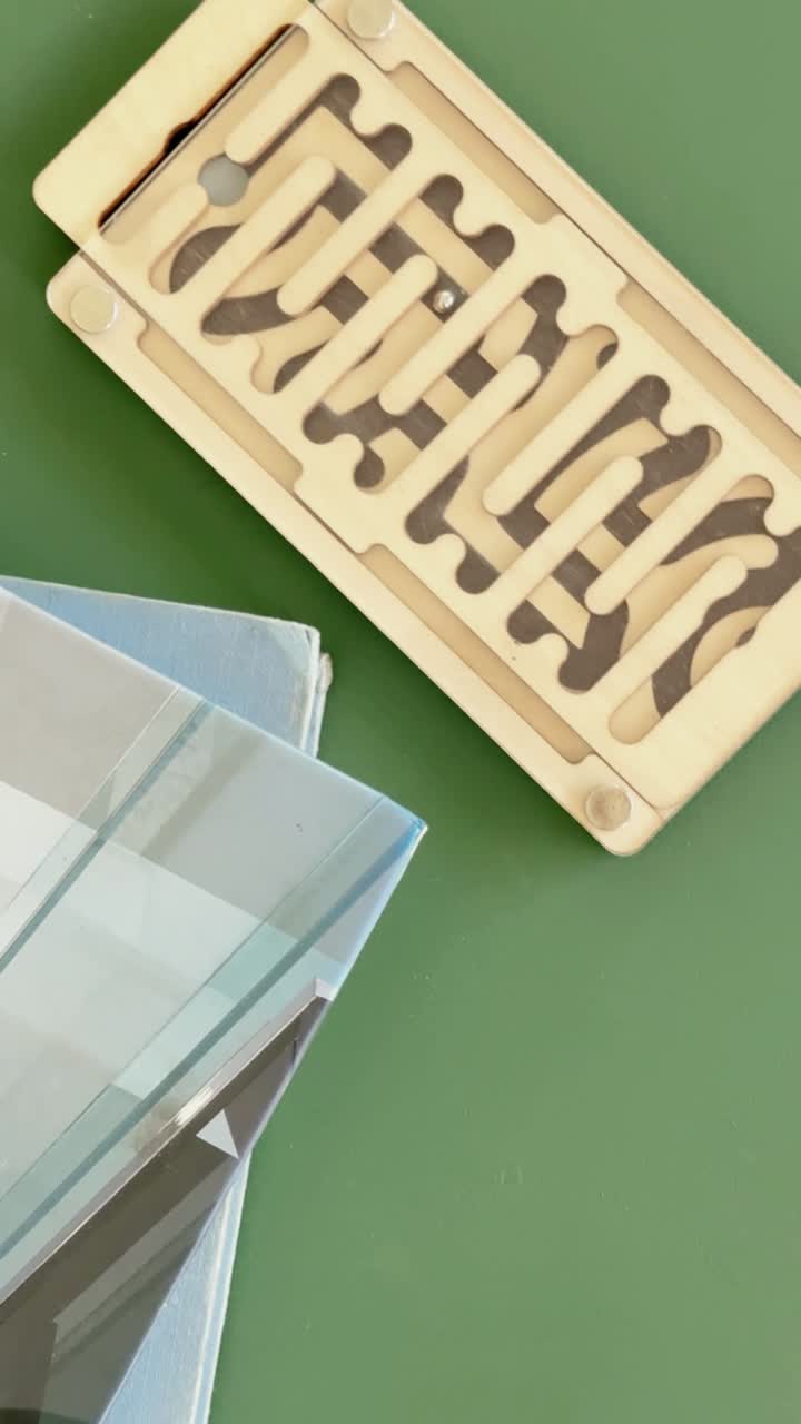 Metallkugel, die sich durch ein Holz-Labyrinth-Puzzle bewegt