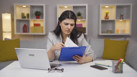 trabajadora de oficina en casa revisando archivos de papeleo.