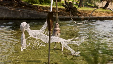 wire fairy sculpture floats gracefully in pond