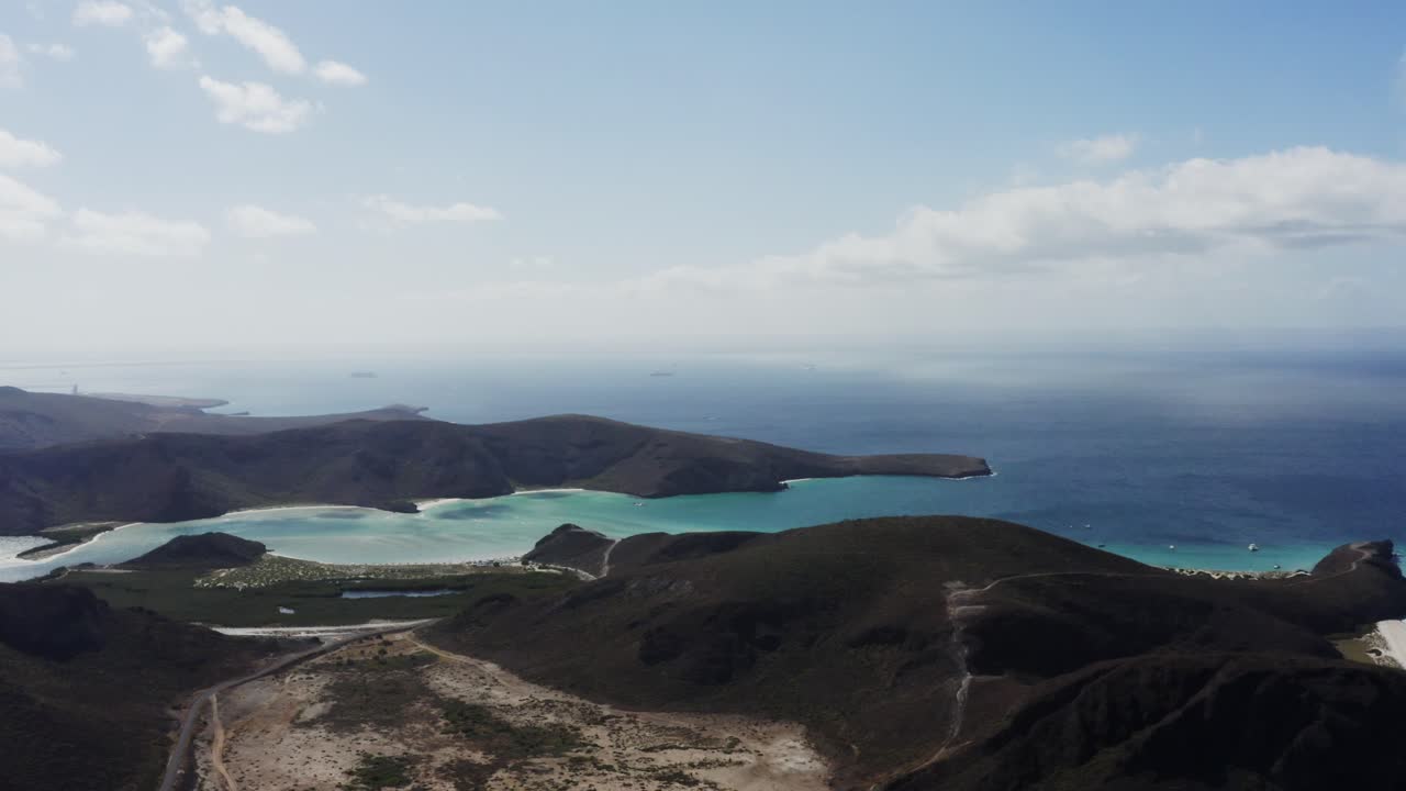 Drone flies above Balandra Beach filming a wide-angle shot.