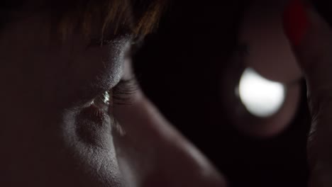 woman looking through the peephole at night, eye close-up