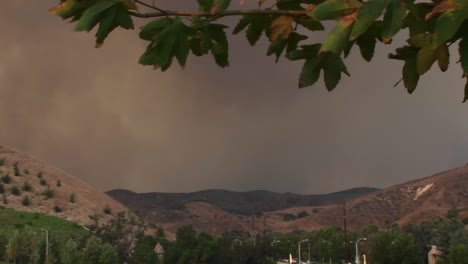 toma de panizquierda de humo que sale de un incendio forestal cerca de una comunidad del sur de california