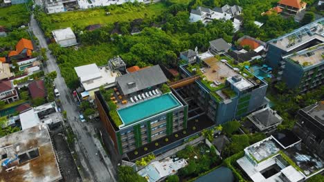 Cinematic-drone-footage-of-Berawa-beach-in-Canggu,-Bali-with-beautiful-landscape,-expensive-hotels-and-villas-through-calm-weather