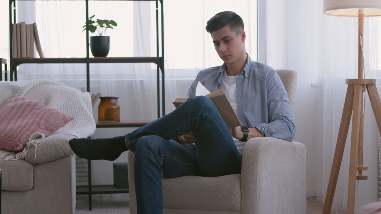 편안한 거실에서 책을 읽는 남자