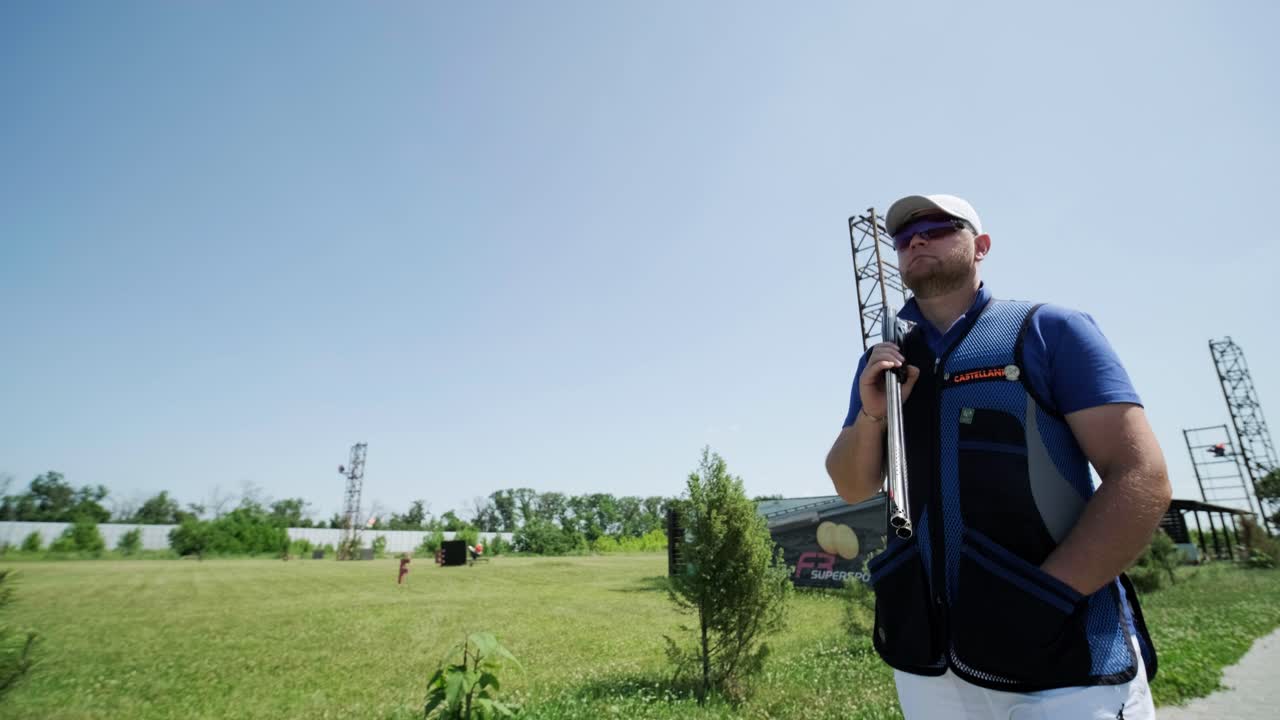 un deportista caminando con una escopeta de doble cañón.