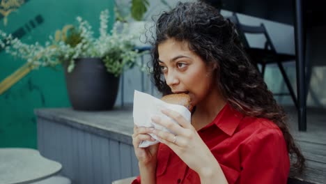 mujer comiendo un sándwich al aire libre