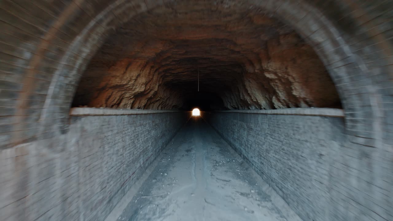 salió disparado hacia un largo y antiguo túnel de hormigón, la salida en el fondo