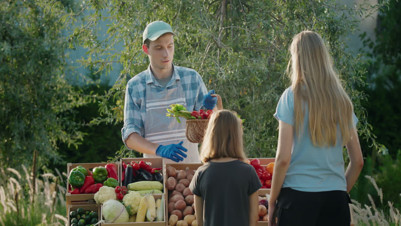 두 소녀 가 농부 시장 에서 채소 를 구입 하고 있다