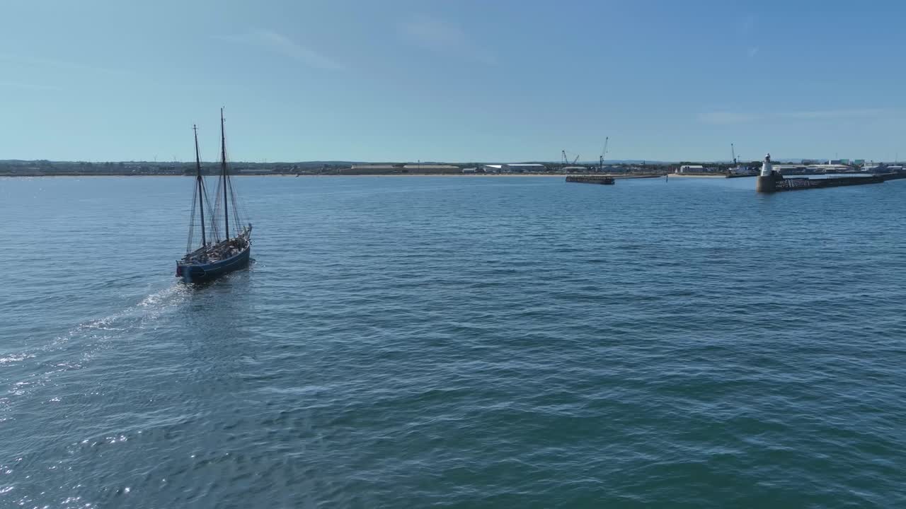 Drone clip showing traditional tall ship sailing into harbour