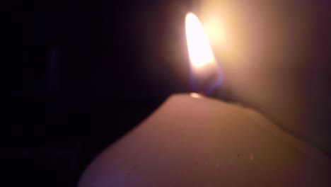 Smoke-surrounding-a-burning-white-candle-close-up-in-a-dark-room