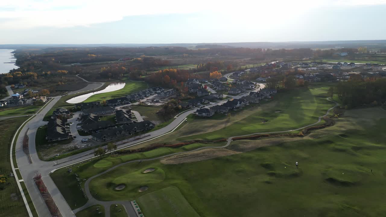 해가 지는 동안 골프 코스 위를 돌고 있는 드론