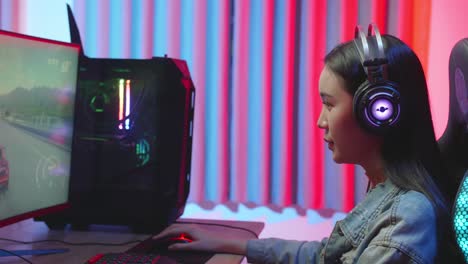 young gamer girl with headphones plays video game