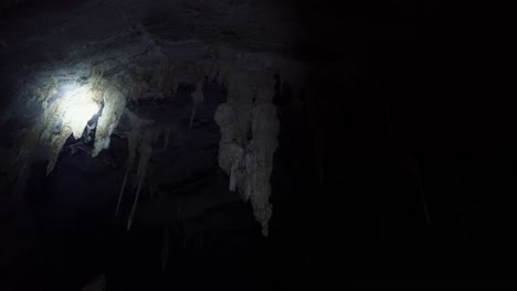 toma manual de una linterna que ilumina varias estalactitas de cuevas grandes dentro de la famosa cueva lapa doce en el parque nacional chapada diamantina en bahia, noreste de brasil