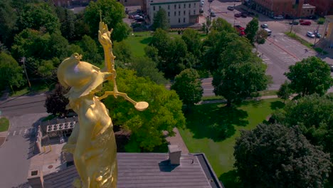 Close-up-of-the-lady-justice-drone-180-move-on-top-of-the-Beautiful-Ontario-County-Courthouse-in-Canandaigua,-New-York-near-Canandaigua-Lake