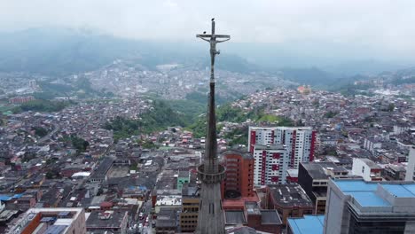 drone alejándose de una estatua de jesucristo en la parte superior de una catedral en manizales en colombia