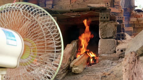 vista amplia del fuego de leña en el horno de cerámica, el ventilador aviva el fuego, que ha vietnam