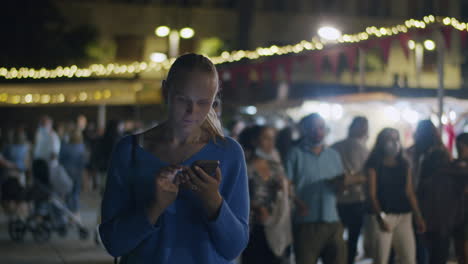 woman chatting on mobile during night city walk