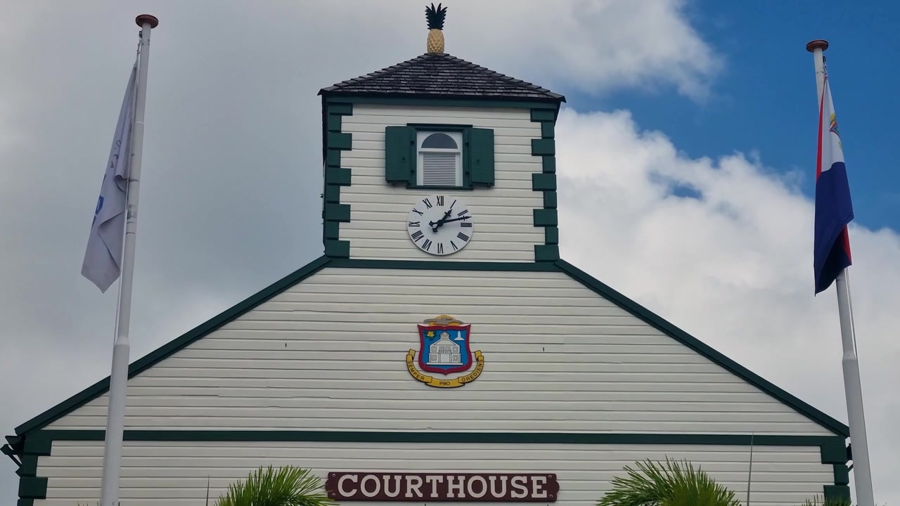 Campanile del tribunale di Philipsburg su Front Street a Sint Maarten, che mostra l'iconica architettura coloniale caraibica, facciata in legno bianco, accenti verdi e torre dell'orologio sormontata da un ananas dorato