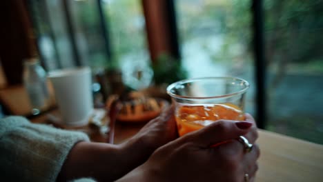 woman enjoying an orange juice in a cozy cafe