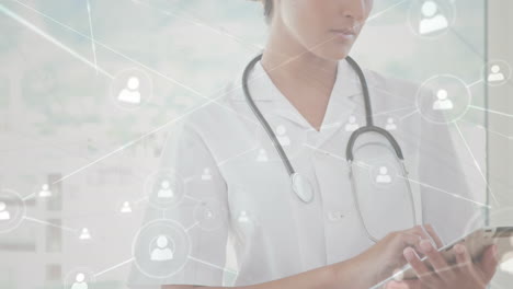 animación de una red de conexiones con iconos sobre una doctora caucásica que usa una tableta