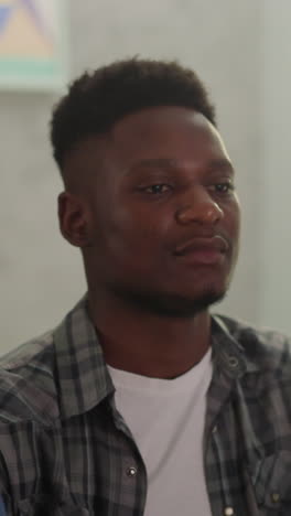 young african-american man with groupmates watches football championship in apartment slow motion. positive sports fans spend evening together