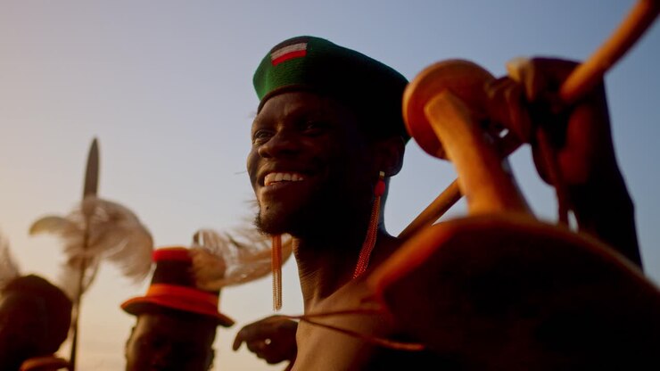 Tradiční afričtí muži držící hole a šípy, usmívající se v Karamoje, Uganda, Afrika - Detailní záběr.