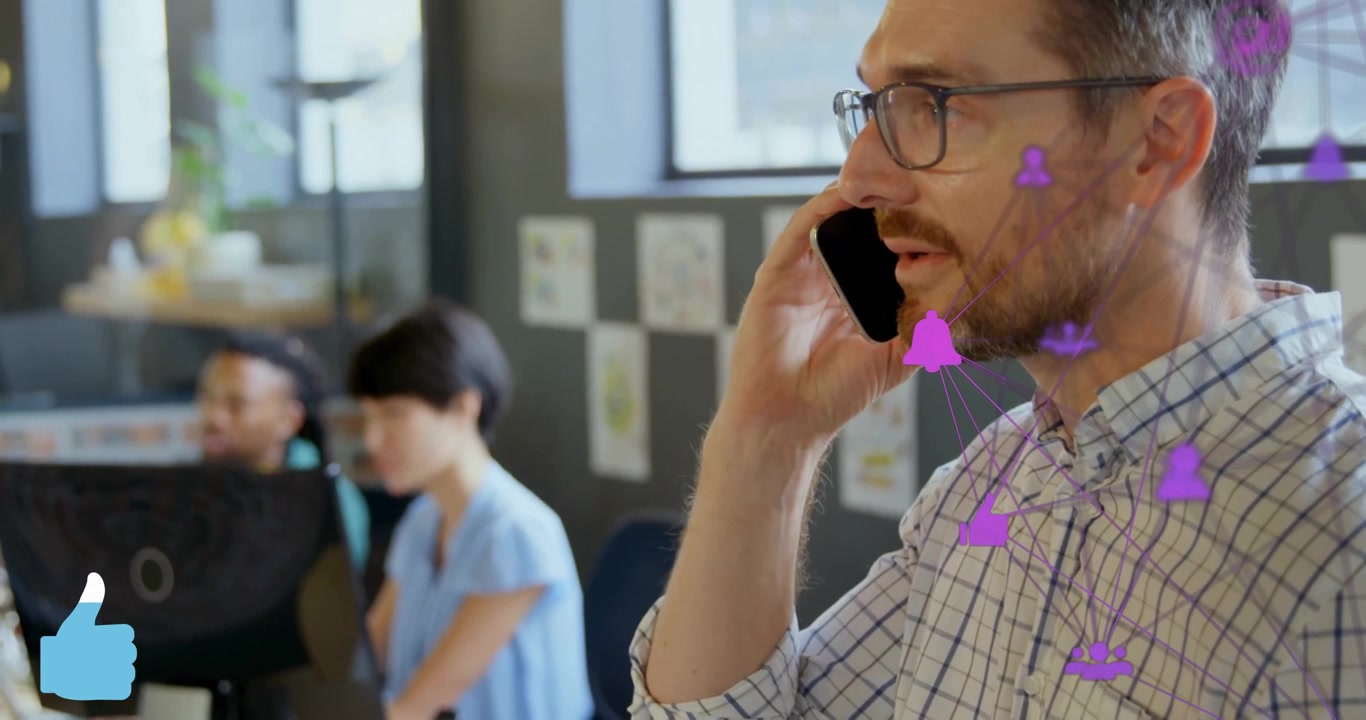 Man speaking on smartphone in office, with animated financial graph rising near monitor