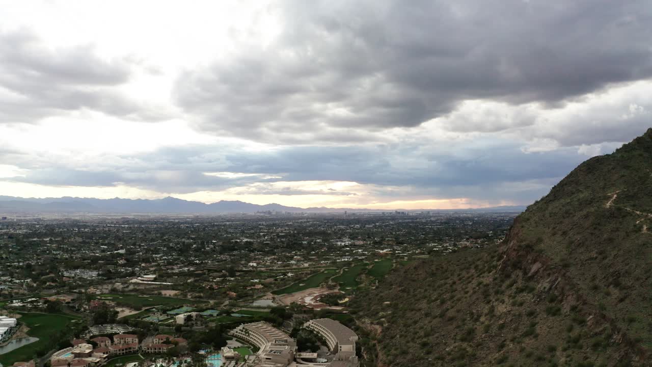 Dolly drone shot showing Scottsdale Arizona's sprawling neighborhoods underneath Camelback Mountain