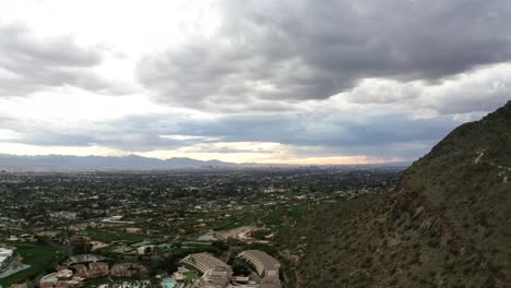 dolly drone shot showing scottsdale arizona's sprawling neighborhoods underneath camelback mountain