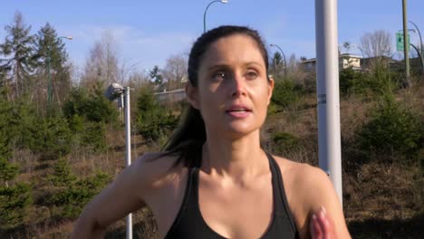 Young-fit-woman-running-up-steps-exercising-outdoors-medium-shot