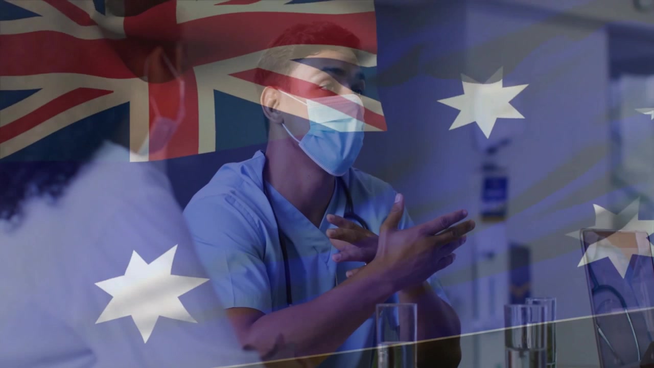 Medico che entra indossando uno stetoscopio, inizia un colloquio sulla salute con un laptop sotto una sovrapposizione di bandiera trasparente.