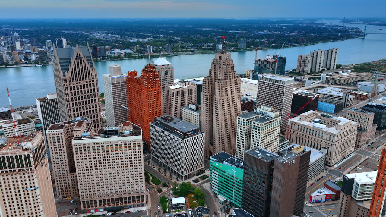 Detroit, USA, 28 July 2025: Diverse high-rises standing close to each other in the downtown of Detroit, Michigan, USA. Approaching the waterscape of the Detroit River at dusk time