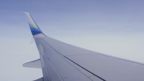 ala de avión de pasajero pov volando a través de cielos azules vuelo