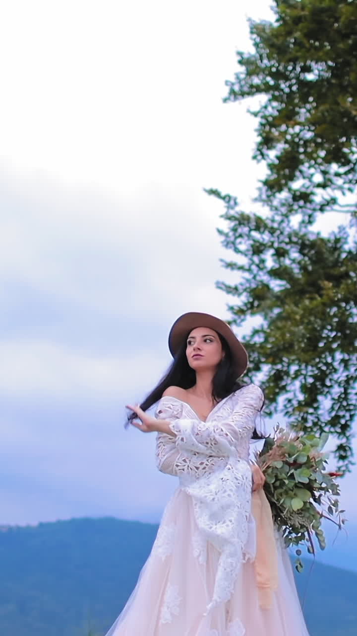 Bride in luxury dress posing outdoors. Beautiful bride in wedding dress posing on the mountains