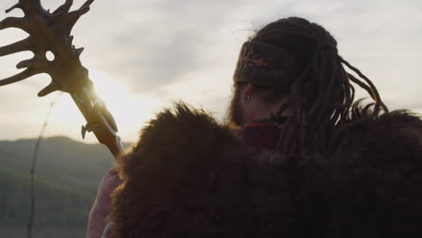 hombre con dreadlocks y capa de piel juega tovshuur en el valle