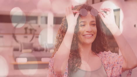 ajuste de gafas de sol, mujer sonriente con animación de luz bokeh en el fondo