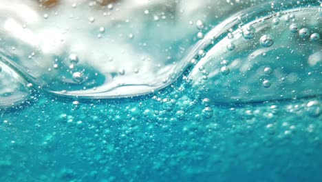 blue liquid background, bubbles move gently within glass container