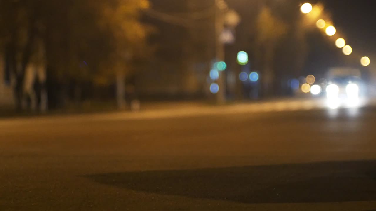 tráfico callejero urbano nocturno de la ciudad. coches a la luz de faros y linternas