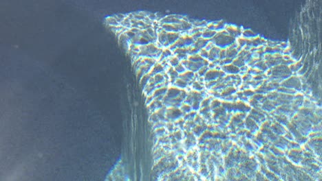 sunlight hitting the water of a hot tub jacuzzi causing patterned ripples in the clear water