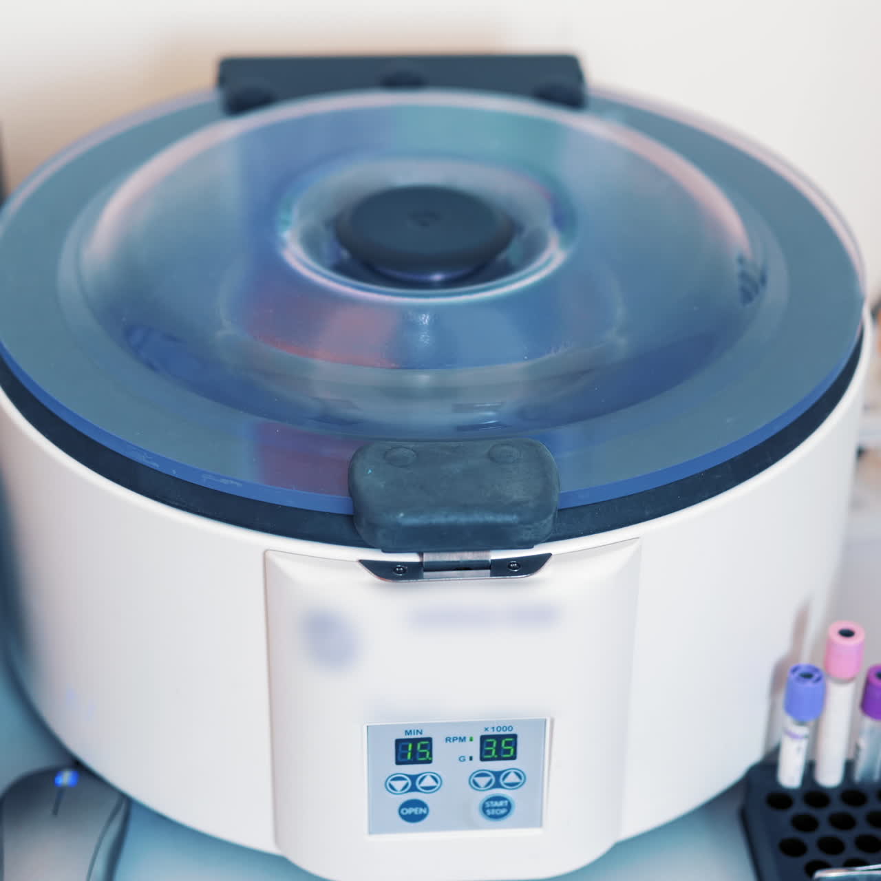 Platelet rich plasma preparation. Tubes with blood in a rack on the table near the automated machine. Modern centrifuge machine in medical laboratory.