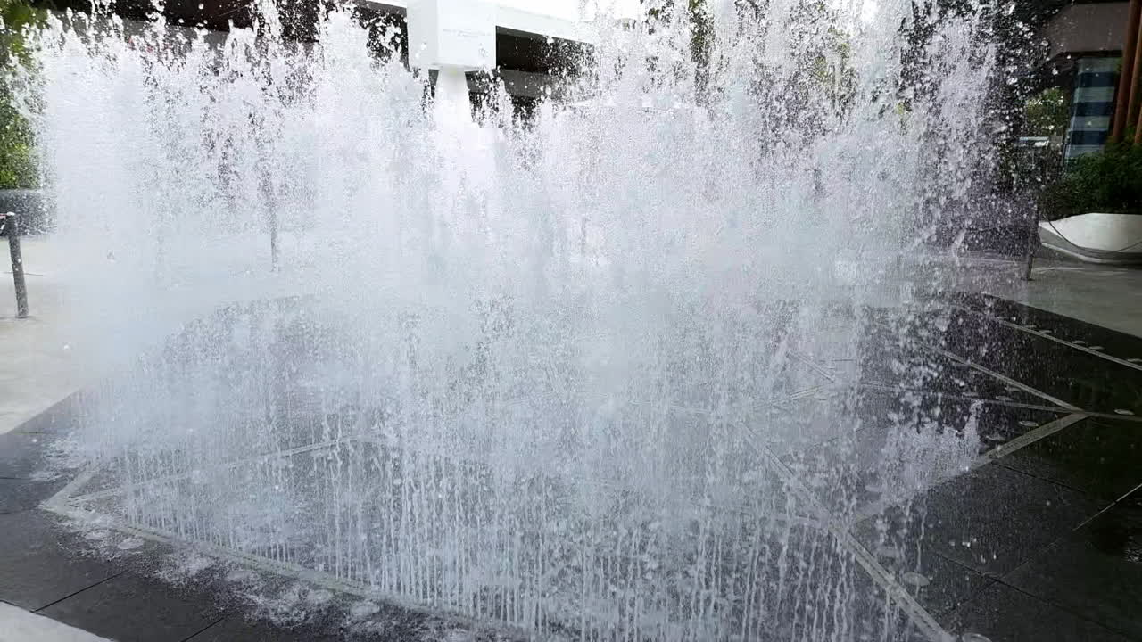 bailando arriba y abajo una fuente de agua está a la vista para que todos la vean en el medio de un centro comercial comunitario en bangkok, tailandia