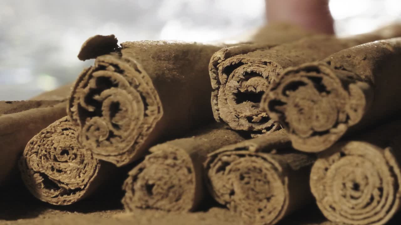 Kanelstang plukkes opp og frigjør kanelpulver, sakte film