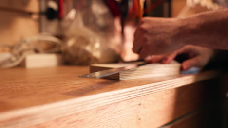 lápiz, manos de carpintero y madera para medir la línea