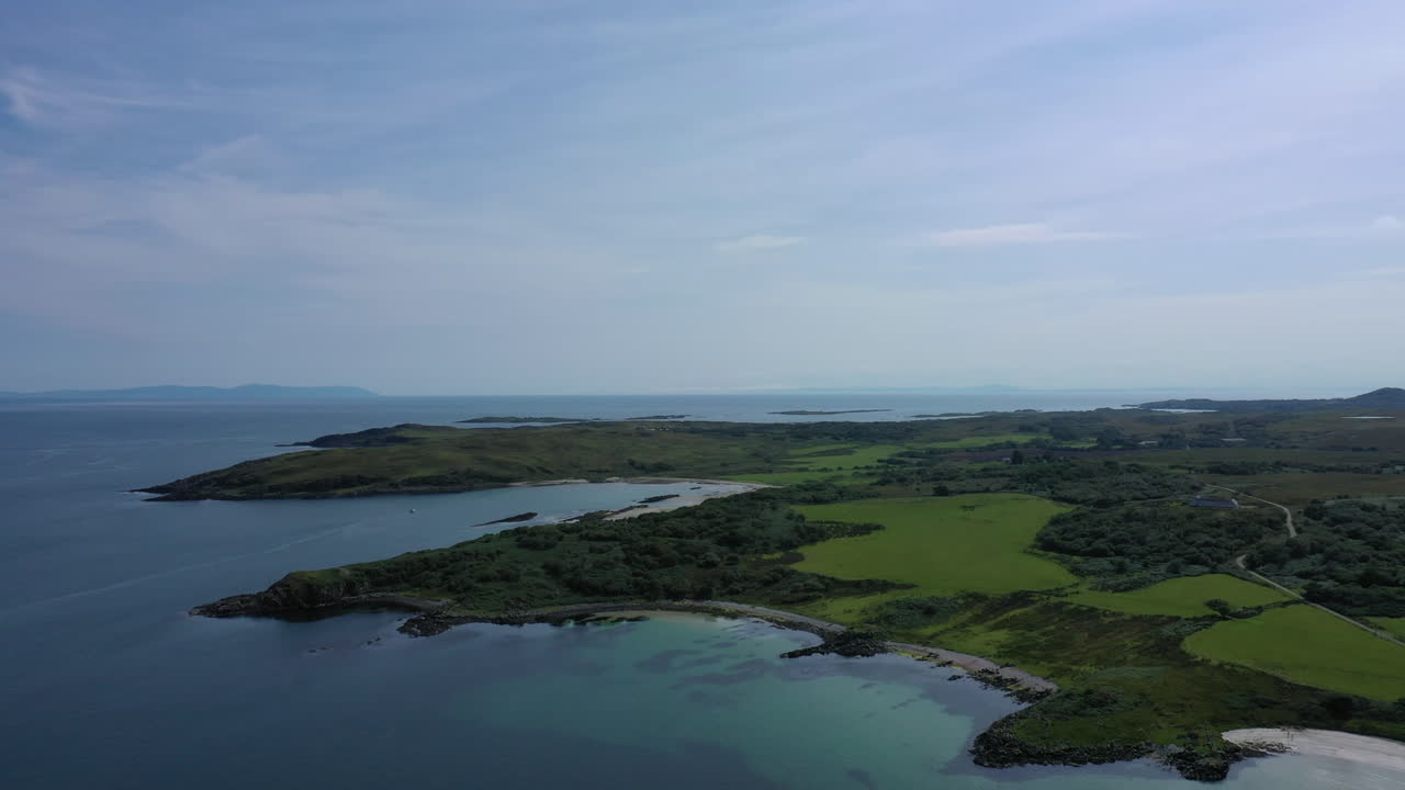 이슬레이 섬 주변의 해안 해역과 육지의 공중 촬영, 버스 하늘과 밝은 파란 물을 보여줍니다.