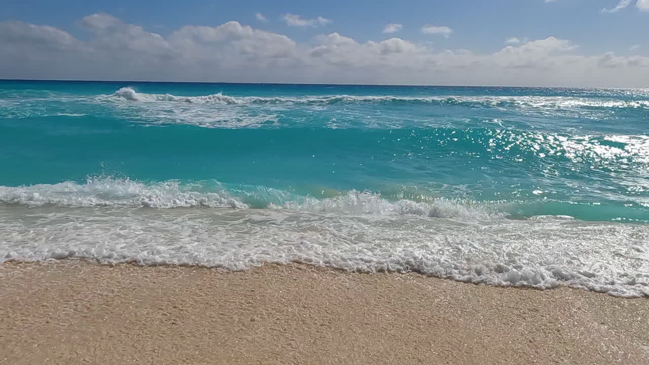 las olas del mar del caribe rompiendo en la playa de arena blanca, en cámara lenta