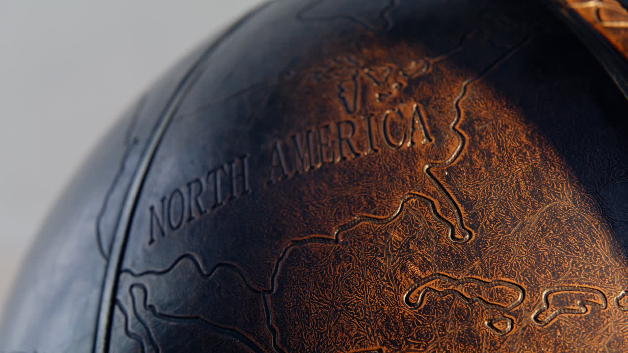 Macro North America globe indoors. Name of continent engraved on leather surface