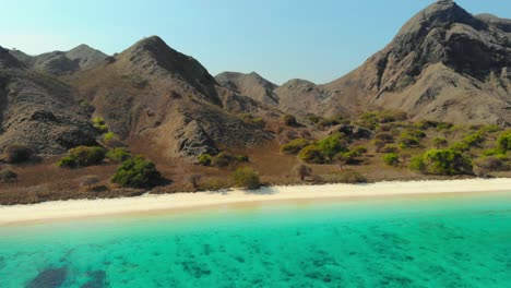 montañas escarpadas y aguas turquesas en la playa rosada de la isla de padar en el parque nacional de komodo, indonesia