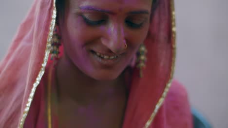 indian women close-up of face smeared with bright holi colors