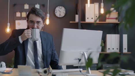 businessman drinking coffee in office